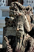 Bangkok Wat Arun - Detail of the precint of the sacred area of the ubosot with chinese noble man sitting on chair. 